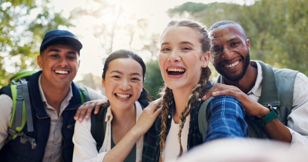 Selfie, hiking and people with smile, diversity and bonding together with journey. Face, outdoor an